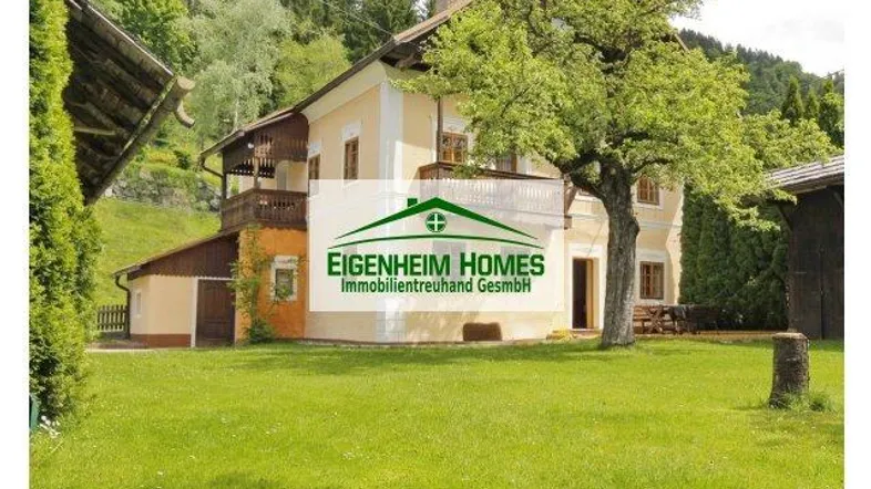 Traditionelles Haus in ländlicher Umgebung mit Balkon und großem Garten.