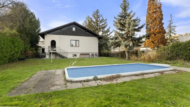Großer Gartenbereich mit Rasenfläche und einem eingelassenen Pool hinter dem Haus.