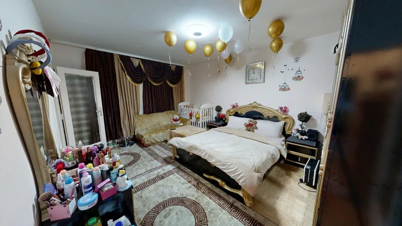 Gemütliches Schlafzimmer mit großem Bett, Babybett und festlicher Ballondekoration.