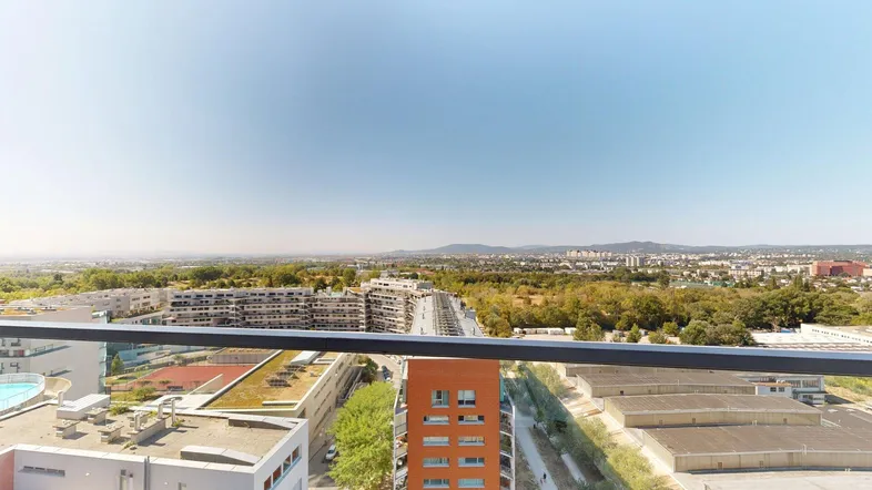 Weitläufiger Ausblick über die Stadt und grüne Landschaften von einem hohen Stockwerk aus.