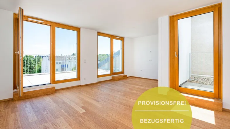 Helles, leeres Zimmer mit Holzboden und großen Fenstern, die Zugang zu einem Balkon bieten.