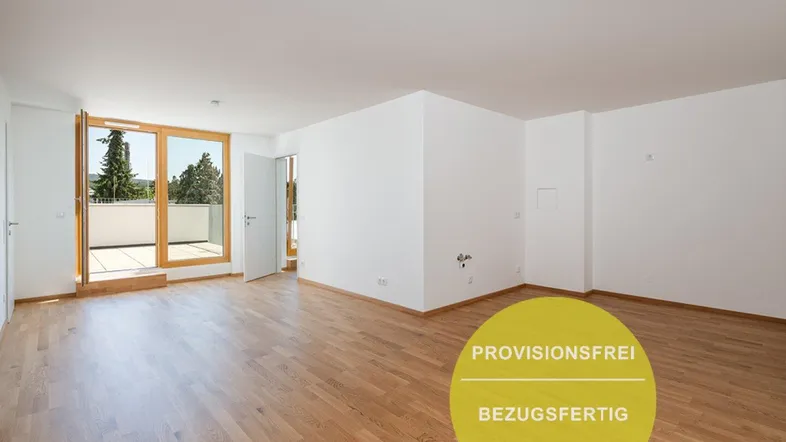 Helles, leeres Wohnzimmer mit Holzboden und Zugang zu einem Balkon in einem Neubau.