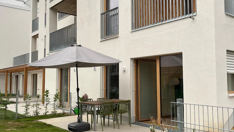 Moderne Wohnanlage mit privater Terrasse und Gartenbereich im Erdgeschoss.