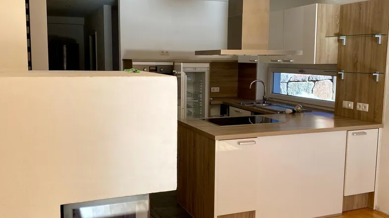 Moderne offene Küche mit Kochinsel, integriertem Kamin und Holzboden.