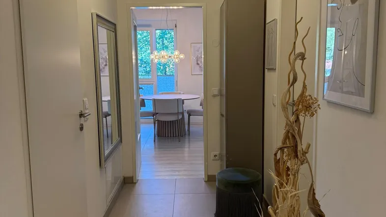 Heller Flur mit Fliesenboden und Blick in den Essbereich, modern dekoriert.