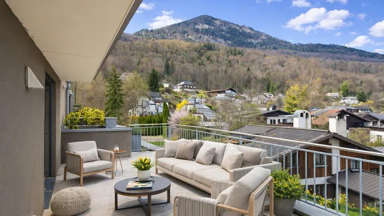 Geräumiger Balkon mit bequemen Gartenmöbeln und einem malerischen Blick auf die Berge und die Stadt.