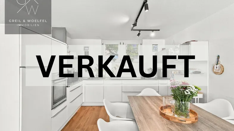 Moderne Küche mit weißen Schränken, Holzboden und Esstisch, leider bereits verkauft.