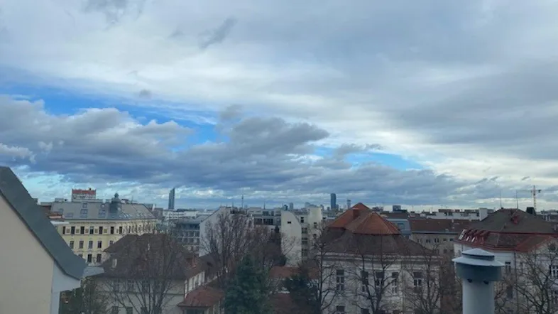 Panoramablick über die Stadt mit bewölktem Himmel und urbaner Architektur im Hintergrund.