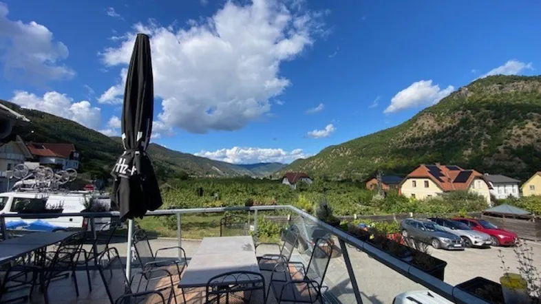 Geräumige Außenterrasse mit Sitzgelegenheiten und einem weiten Blick auf die umliegenden Weinberge und Berge.