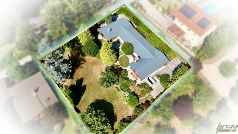 Luftaufnahme eines Hauses mit großem Garten und umliegender grüner Landschaft.