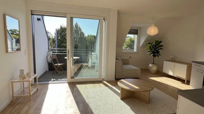 Helles Wohnzimmer mit Holzboden, modernem Mobiliar und direktem Zugang zum Balkon.