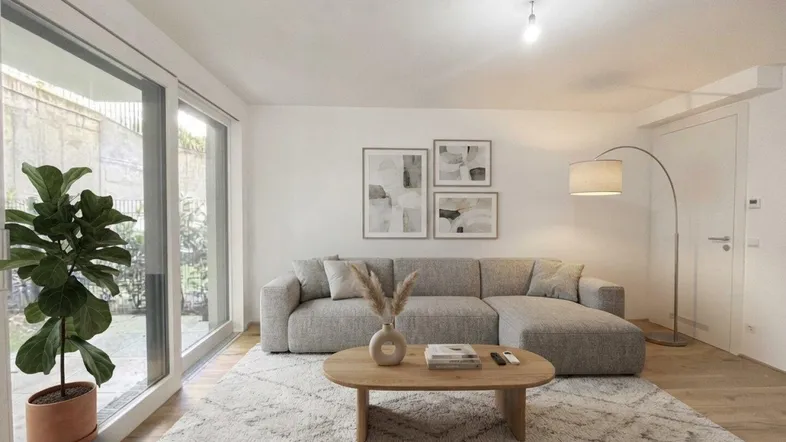 Helles Wohnzimmer mit modernem Sofa, Teppich und großen Fenstern zum Garten.