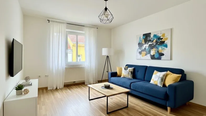 Helles Wohnzimmer mit modernem Sofa, Holzboden und dekorativem Kunstwerk an der Wand, ideal zum Entspannen.