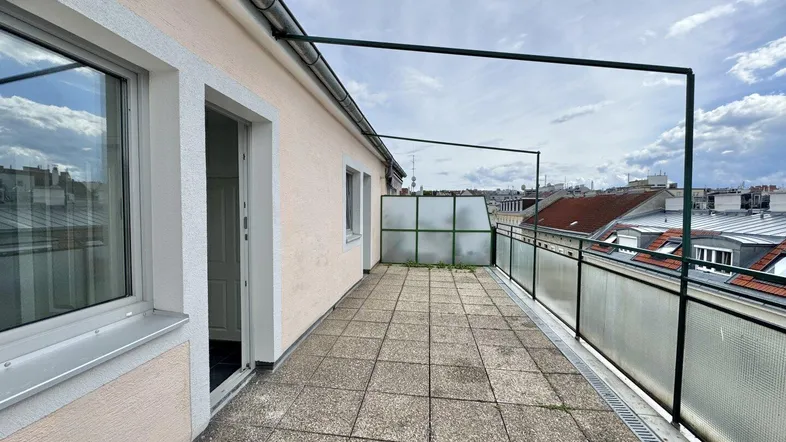 Geräumige Dachterrasse mit Fliesenboden und Blick über die Dächer der Stadt, ideal für Entspannung im Freien.