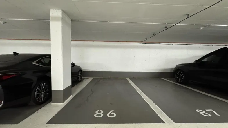 Tiefgaragenstellplätze mit klar markierten Parkbuchten und Betonwänden in einem gepflegten Zustand.