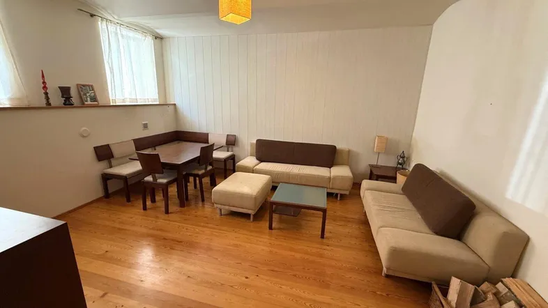 Gemütlicher Wohn- und Essbereich mit Holzboden, bequemen Sofas und einem Esstisch für gesellige Stunden.