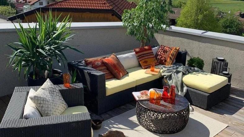 Geräumige Dachterrasse mit bequemen Loungemöbeln und atemberaubendem Bergblick.