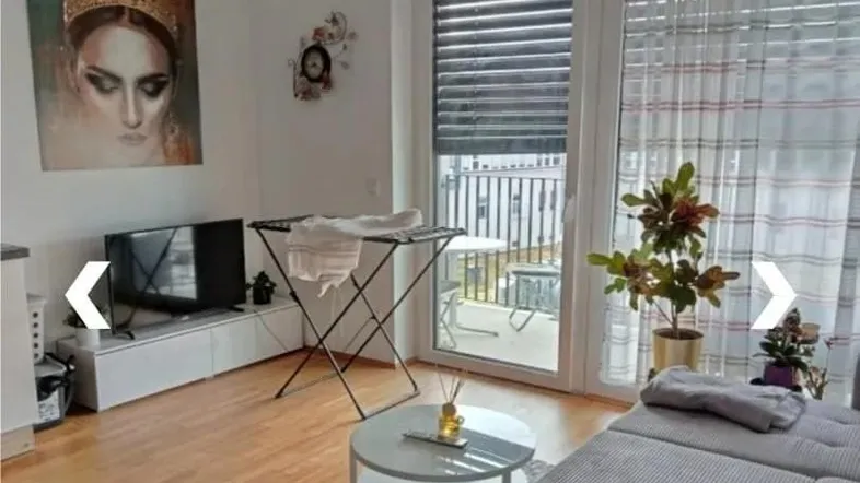 Helles Wohnzimmer mit Parkettboden, Zugang zum Balkon und moderner Einrichtung, ideal zum Entspannen.