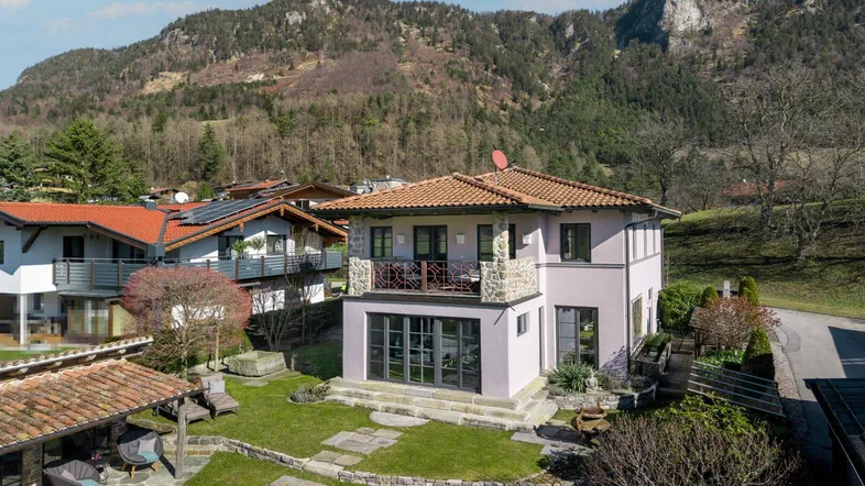 Großzügiges Anwesen mit gepflegtem Garten, Steinterrasse und beeindruckendem Bergblick.