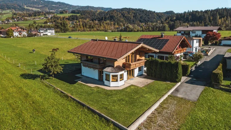 Idyllisches Einfamilienhaus in ländlicher Umgebung mit weiten Grünflächen und Bergblick.