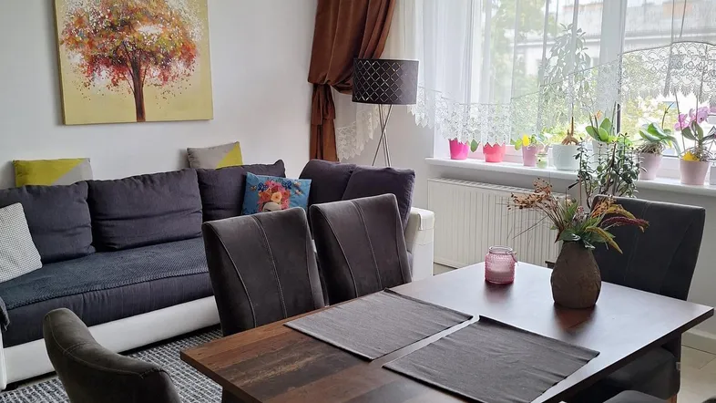 Heller Wohn- und Essbereich mit modernem Esstisch, bequemer Couch und Blick ins Grüne.