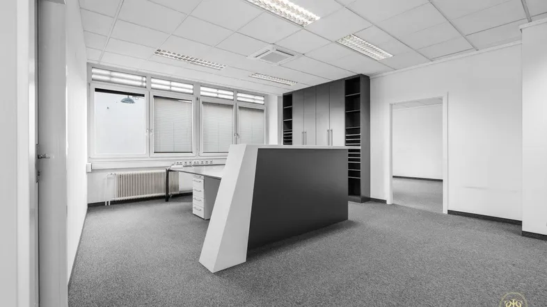 Helles Büro mit Empfangstheke, Einbauschränken und Teppichboden, ideal für moderne Arbeitsumgebungen.