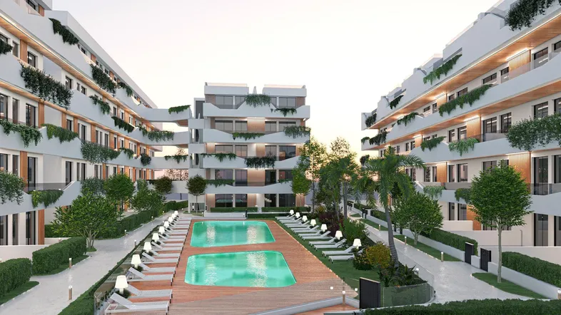 Moderne Wohnanlage mit mehreren Gebäuden, großem Poolbereich und Liegestühlen im Freien.