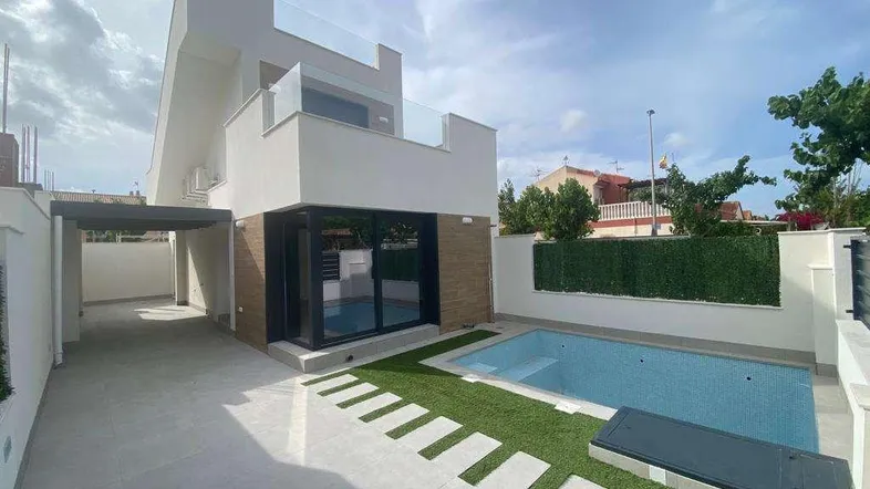 Moderne Villa mit privatem Pool, gefliester Terrasse und Carport im Freien.