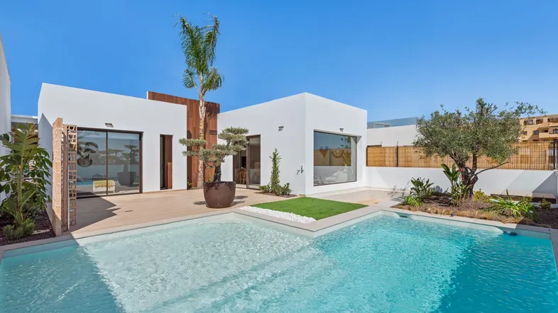 Moderne Villa mit privatem Pool und sonniger Terrasse, umgeben von mediterraner Bepflanzung.