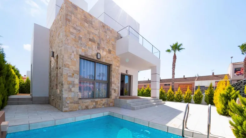 Moderne Villa mit Steinfassade, privatem Pool und sonniger Terrasse.