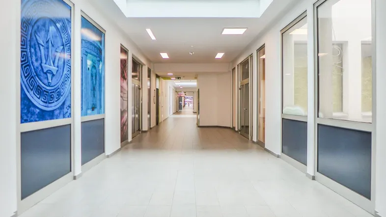 Helle, lange Flurpassage mit vielen Glasfronten und Oberlichtern, die zu verschiedenen Räumen führt.