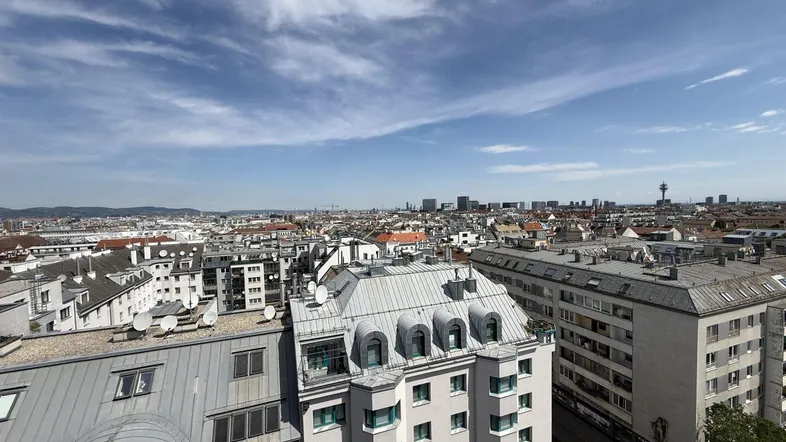 Panoramablick über die Stadt Wien mit zahlreichen Gebäuden und einem weiten Himmel.
