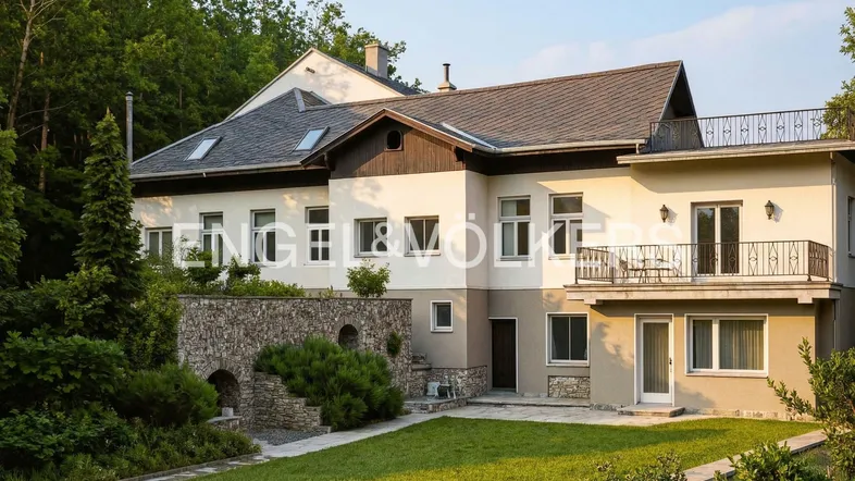 Großzügige Villa mit gepflegtem Gartenbereich und Steinelementen in natürlicher Umgebung.
