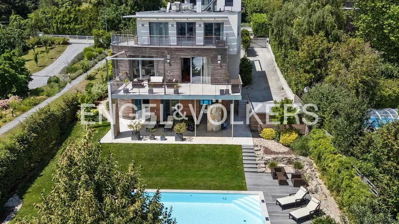 Moderne Villa mit mehreren Terrassen, Pool und gepflegtem Gartenbereich in Hanglage.