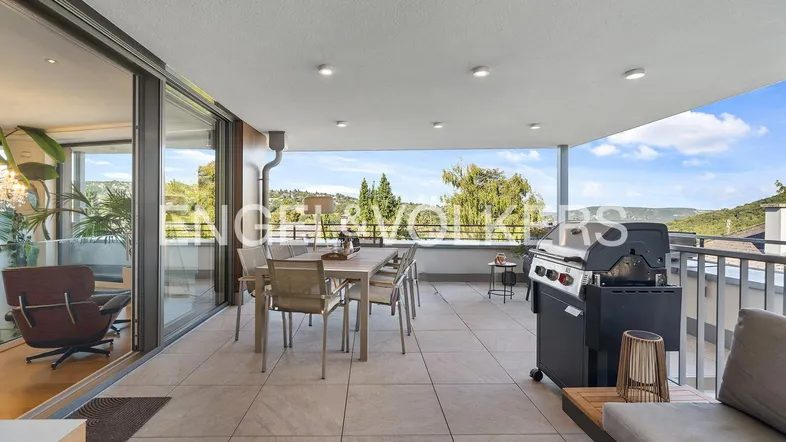 Geräumige Terrasse mit Essbereich, Grill und weitem Blick ins Grüne, ideal für gesellige Abende.