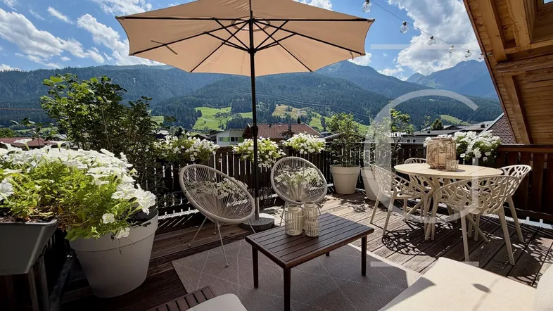 Große Terrasse mit Sitzgelegenheiten, Sonnenschirm und herrlichem Bergblick.