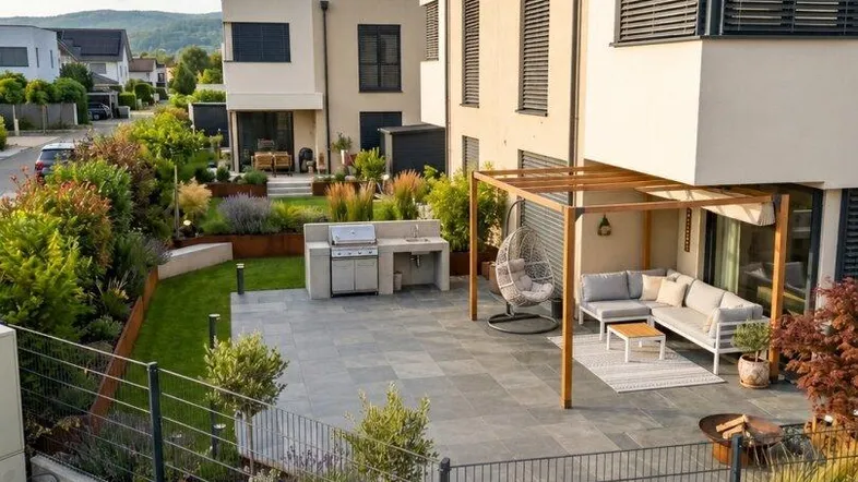 Moderne Reihenhaus-Terrasse mit Pergola, Grillbereich und gemütlicher Lounge-Ecke, umgeben von einem gepflegten Garten.