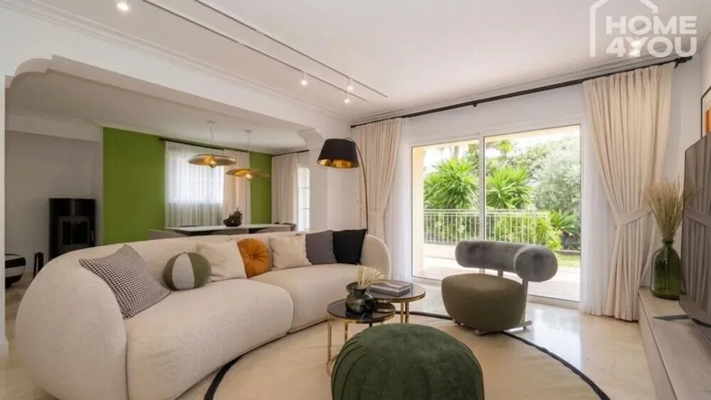 Helles, modernes Wohn-Esszimmer mit bequemer Couch, stilvollem Esstisch und Zugang zur Terrasse.