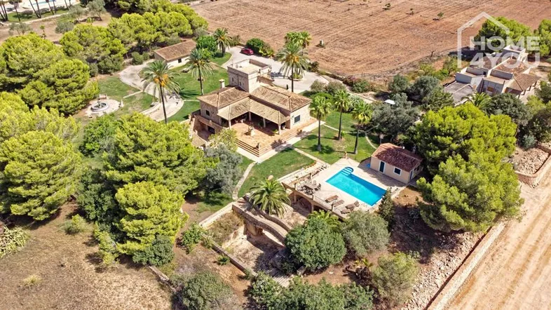 Luftaufnahme des weitläufigen Anwesens mit Haupthaus, großem Garten, Pool und umliegenden Feldern.