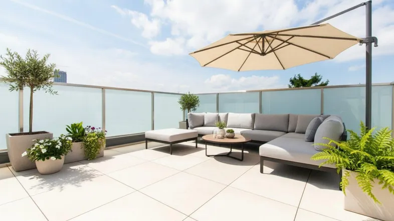 Geräumige Dachterrasse mit modernen Loungemöbeln, Sonnenschirm und Pflanzen für entspannte Stunden im Freien.