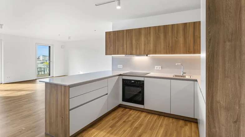 Moderne Einbauküche mit Holz- und weißen Fronten, integrierten Geräten und Zugang zum Balkon.