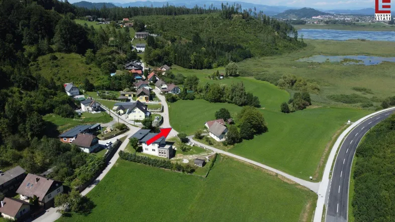 Luftaufnahme des Anwesens mit umliegender Natur, See und Straße.
