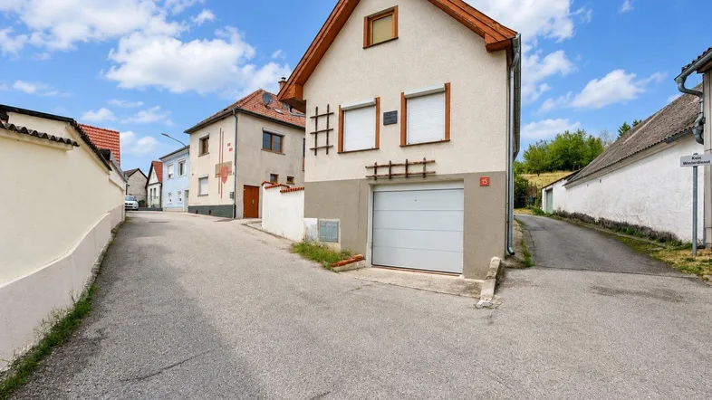 Einfamilienhaus mit integrierter Garage an einer ruhigen Dorfstraße.