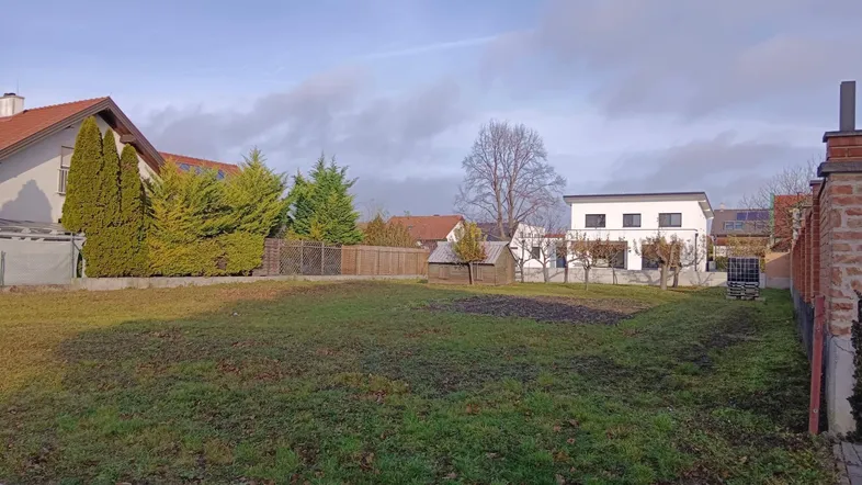 Großes Grundstück mit Rasenfläche und umgebenden Wohnhäusern in ländlicher Umgebung.