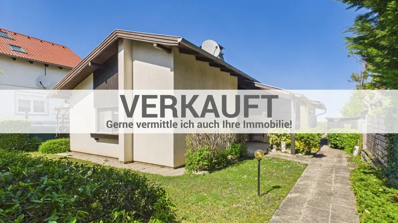 Außenansicht eines Einfamilienhauses mit gepflegtem Garten und Gehweg unter blauem Himmel.