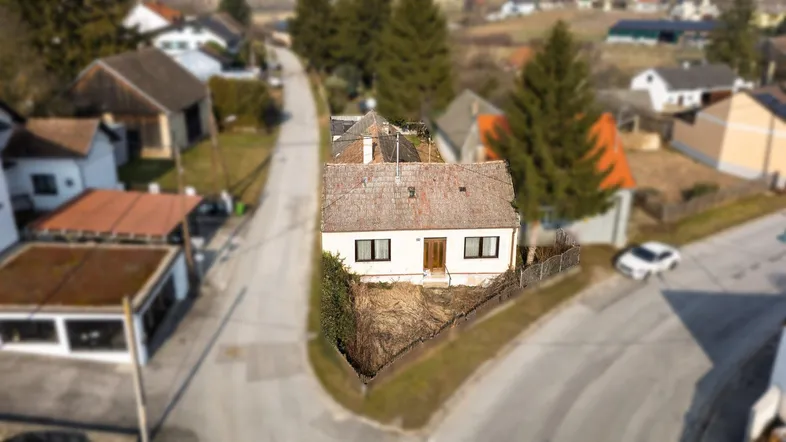 Luftaufnahme eines Einfamilienhauses mit Satteldach in ländlicher Umgebung.