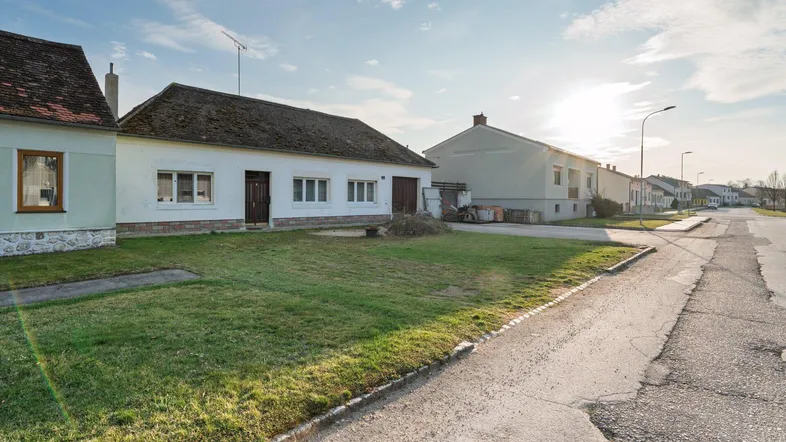 Ländliches Einfamilienhaus mit Vorgarten und Zufahrt in sonniger Umgebung.