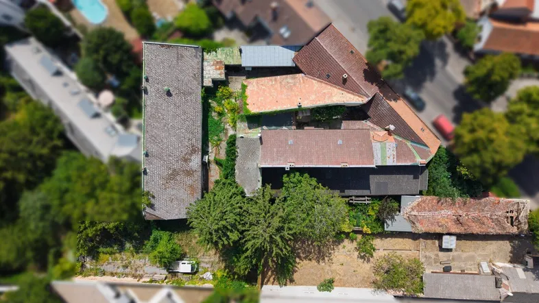 Luftaufnahme des Anwesens mit umliegenden Gebäuden und viel Grün in der Nachbarschaft.