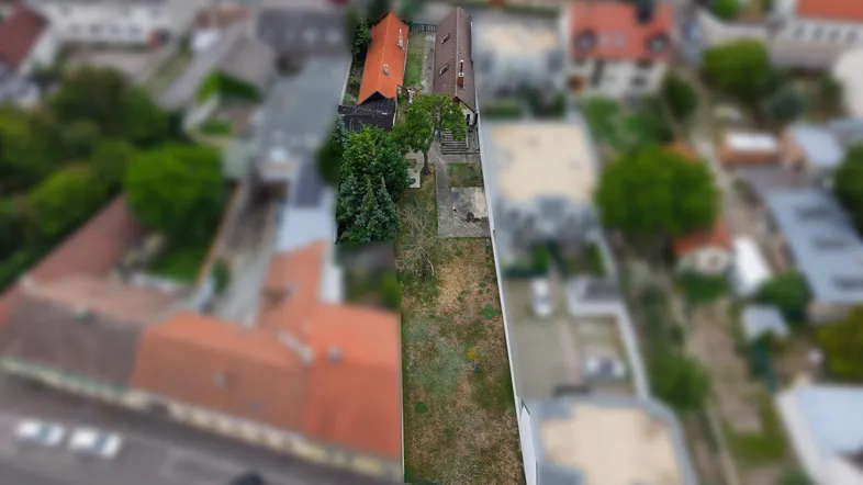 Luftaufnahme des Grundstücks und der umliegenden Bebauung mit Fokus auf die lange Parzelle.