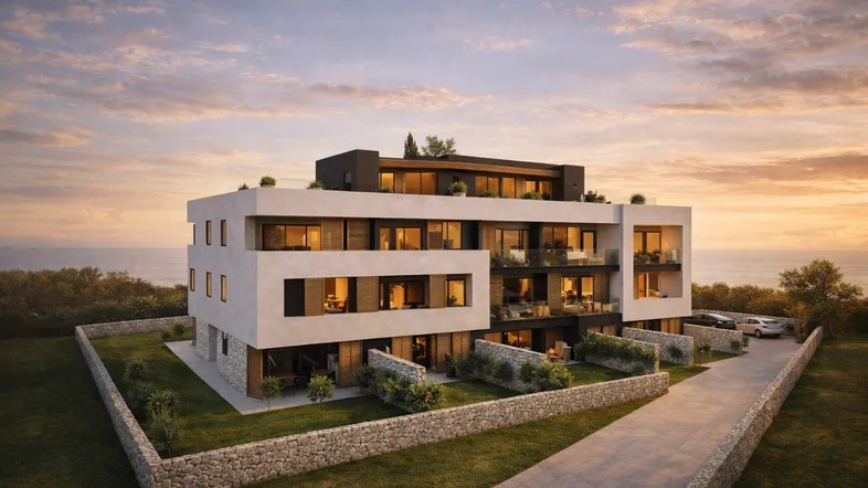 Moderne Wohnanlage mit Meerblick bei Sonnenuntergang, umgeben von Grünflächen und Steinmauern.